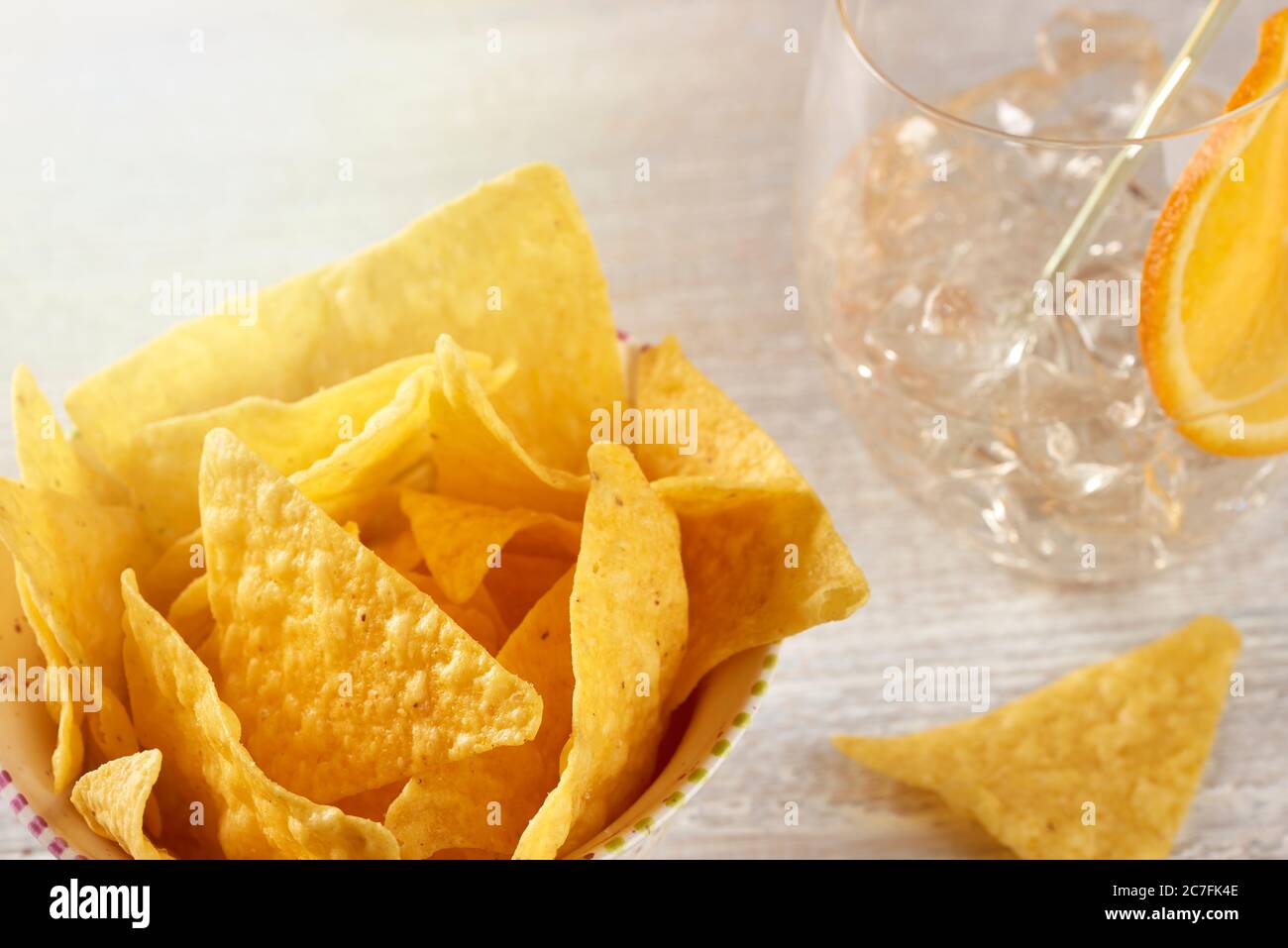 Una tazza piena di patatine croccanti sul tavolo con un bicchiere di cocktail rinfrescante. Foto Stock