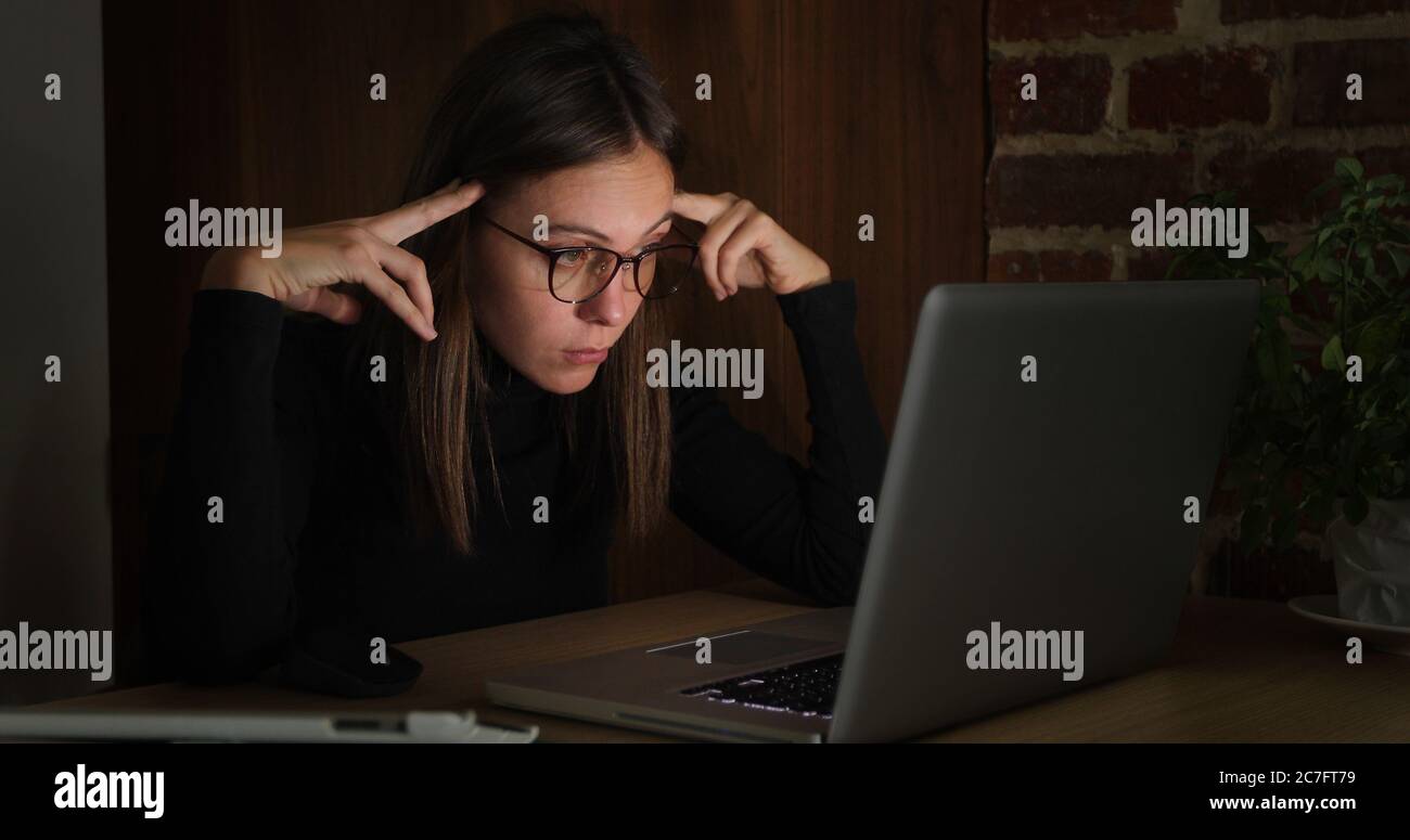 Donna che lavora di notte con un computer portatile Foto Stock