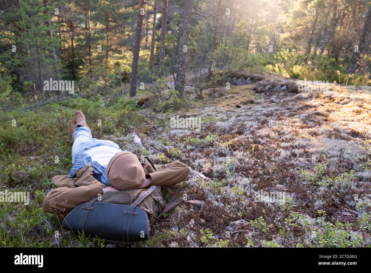 L'uomo giace sull'erba, riposandosi nel mezzo della foresta rilassante Foto Stock