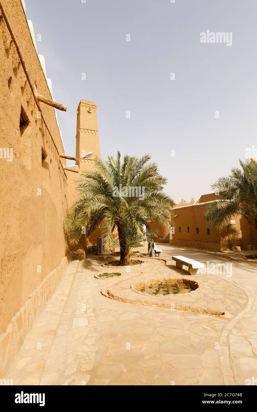 Vicolo con palme e case rinnovate nel villaggio tradizionale di Shaqra in Arabia Saudita. Shaqra è un villaggio tradizionale restaurato fatto di argilla Foto Stock