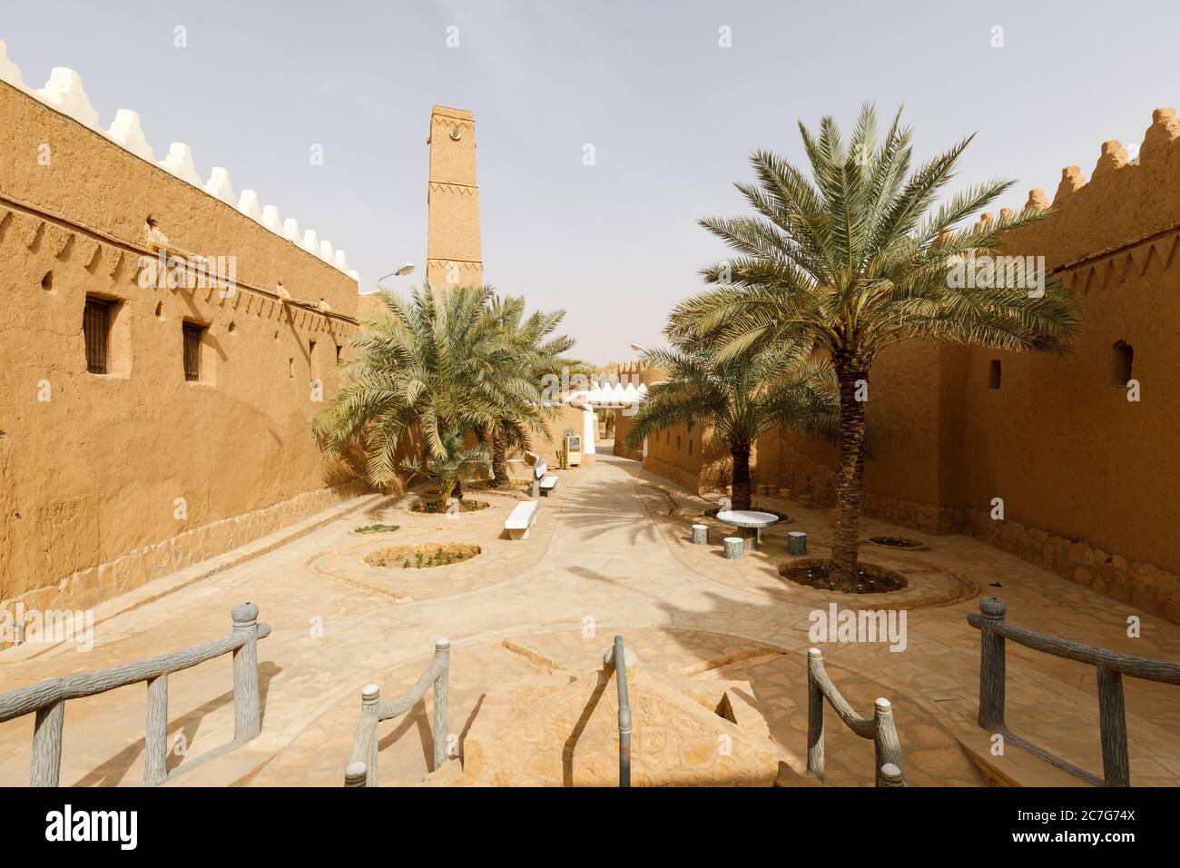 Vicolo con palme e case rinnovate nel villaggio tradizionale di Shaqra in Arabia Saudita. Shaqra è un villaggio tradizionale restaurato fatto di argilla Foto Stock