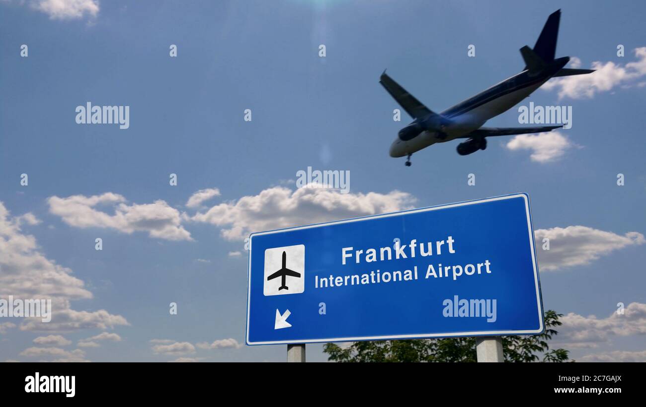 Atterraggio di silhouette di aeroplano a Francoforte, Germania, Europa. Arrivo in città con cartello con la direzione dell'aeroporto internazionale e cielo blu sullo sfondo. Tra Foto Stock