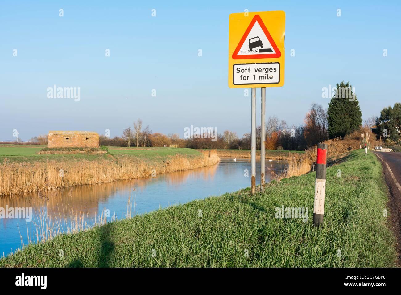 Segnale di pericolo, vista di un segnale di avvertimento del rischio di veicoli che scivolano in un canale di fenland a Benwick a Cambridgeshire, Inghilterra, Regno Unito Foto Stock