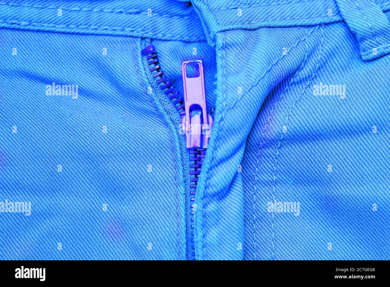Jeans blu con un bottone rosa. Stile creativo minimo. Foto Stock