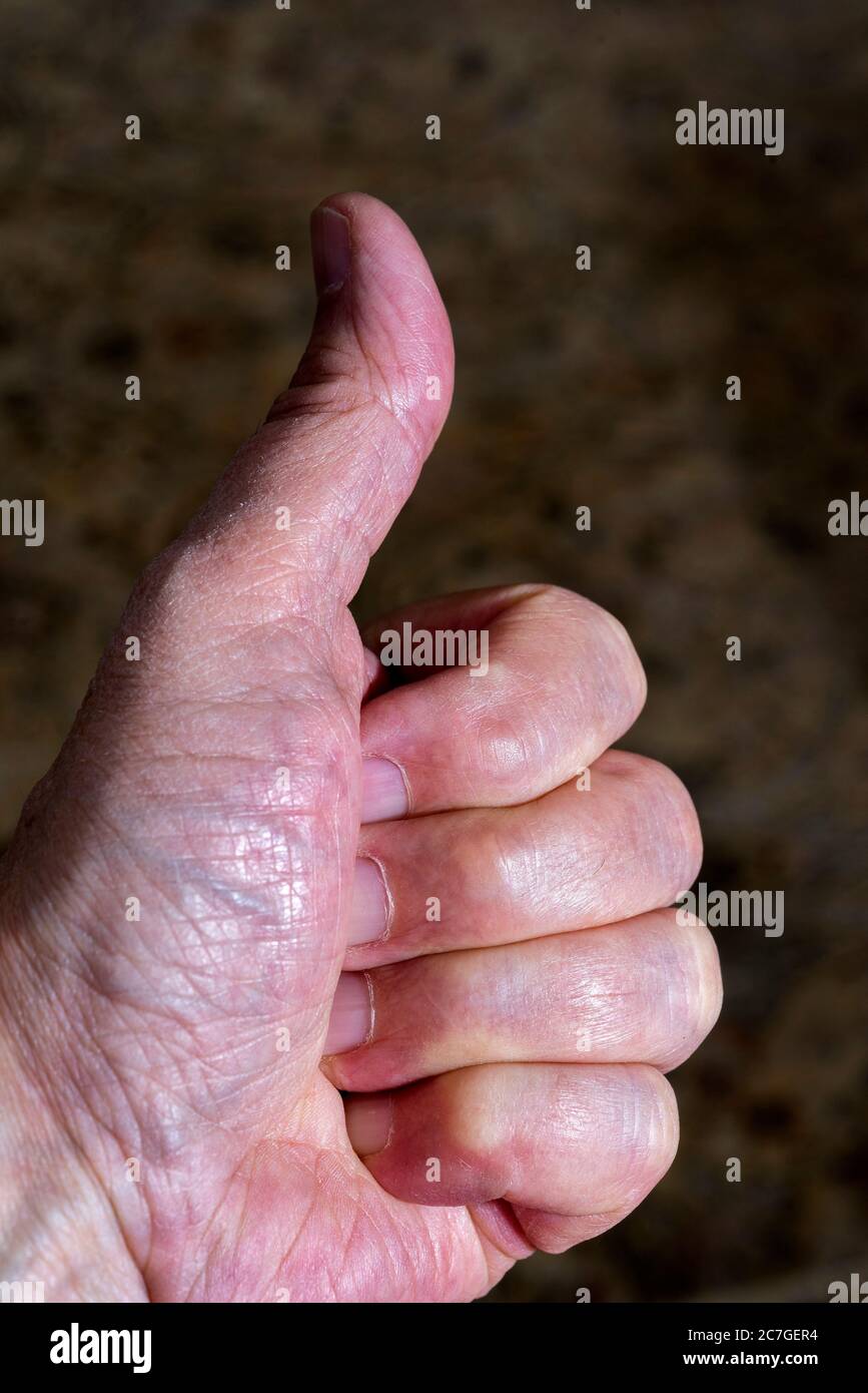 Una mano di mans che mostra pollici in su segno. Foto Stock