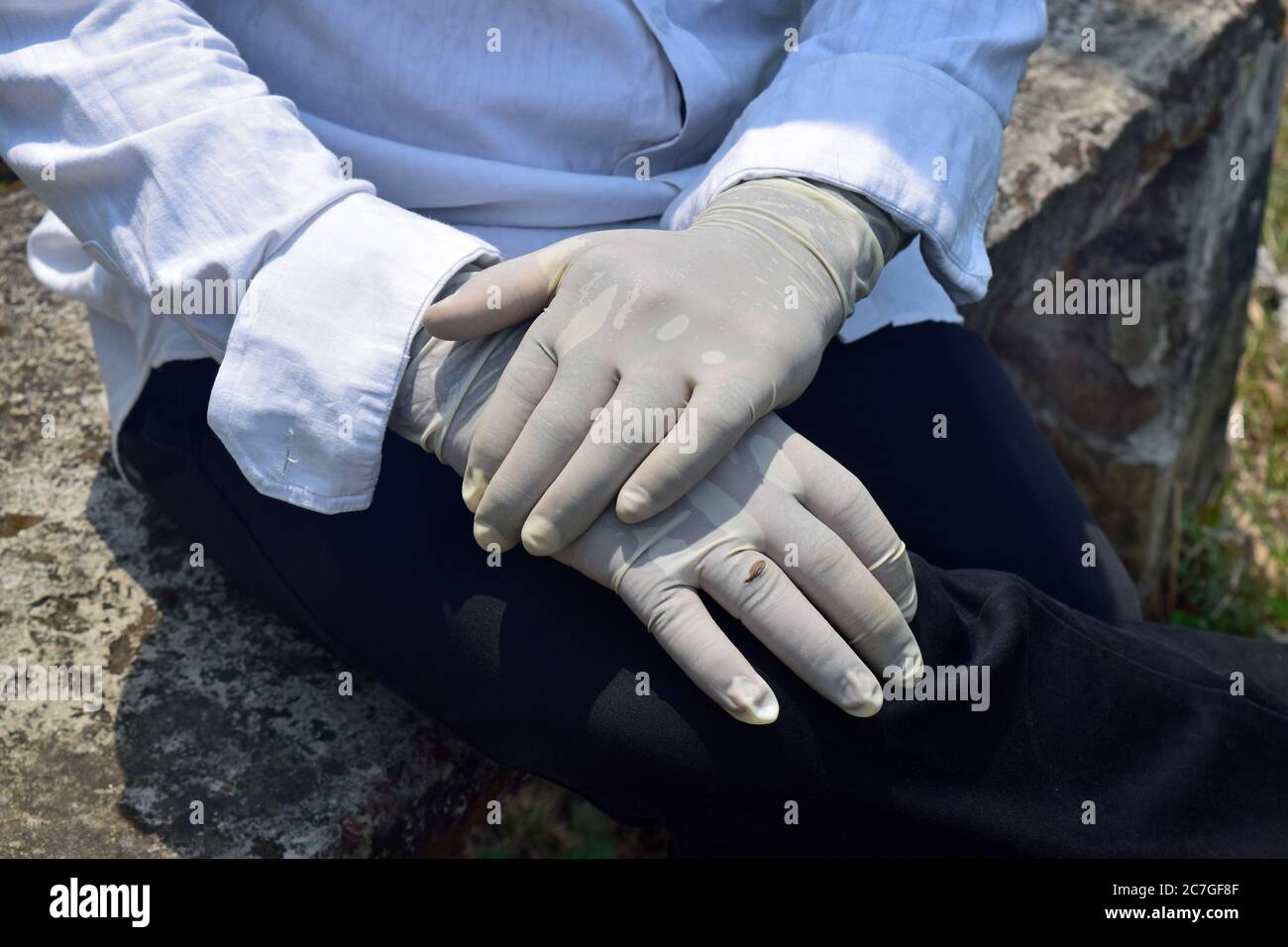 Guanti medici bianchi sulle mani su sfondo verde. Primo piano. Pronto per il trattamento medico , medico indossando una camicia bianca e una maschera e h e guanti. D Foto Stock