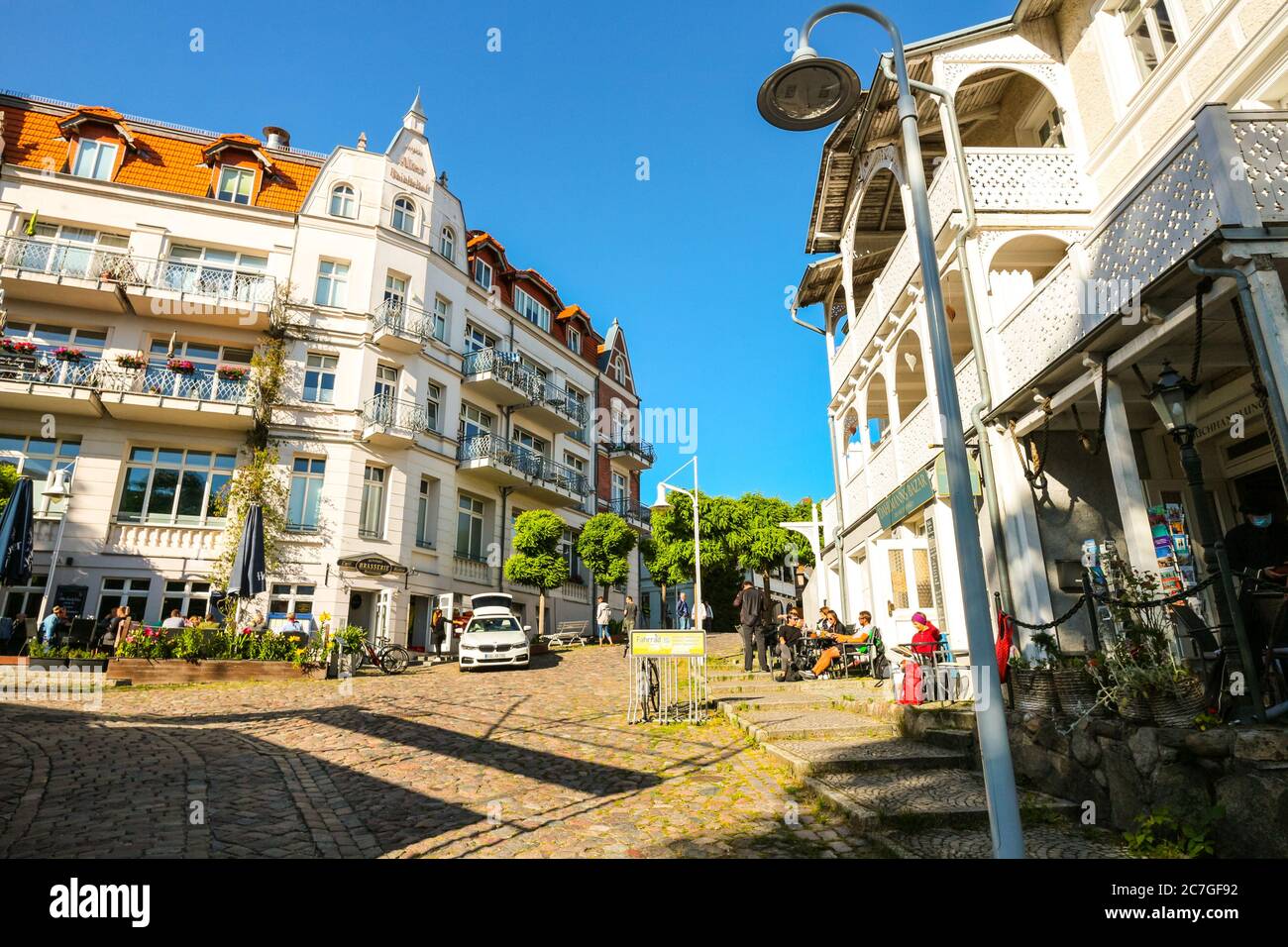 Piccola piazza nel centro storico di Sassnitz, sull'isola di Rügen, in Germania; caffetterie e ristoranti costeggiano la strada acciottolata con l'architettura tipica. Foto Stock