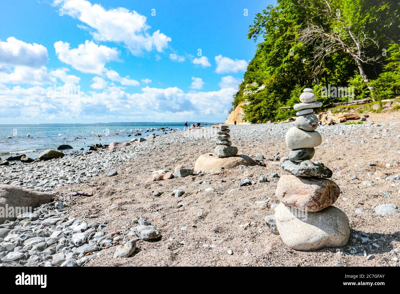 Pietre impilate (Cairns) sulla spiaggia di ciottoli con scogliere di gesso sulla spiaggia di Piratenschlucht sul Mar Baltico nel Parco Nazionale di Jasmund, Rügen, Germania. Foto Stock