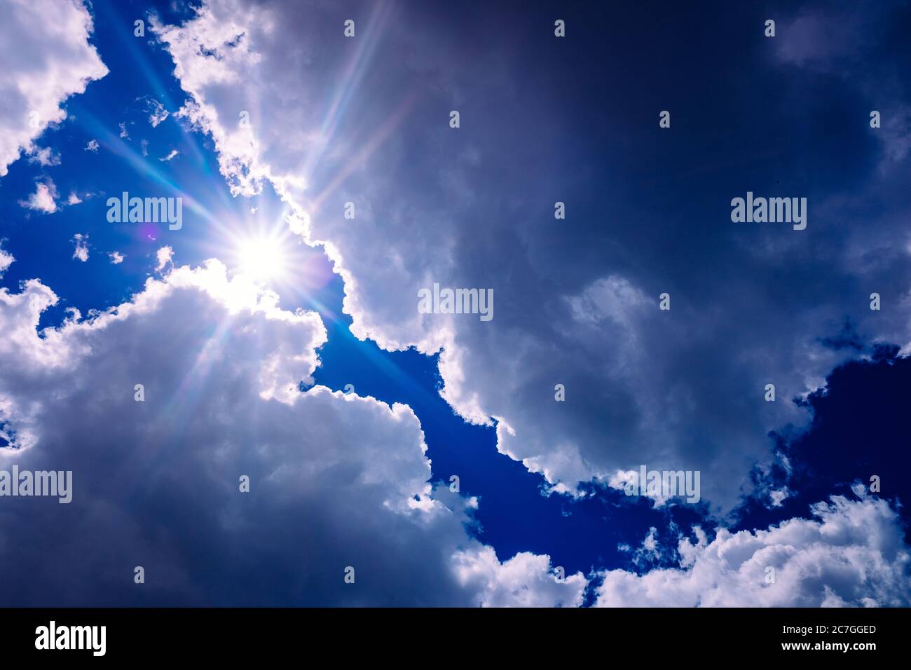 Il sole sorge tra le nubi di tempesta bluastre ispirate alla divina. Foto Stock
