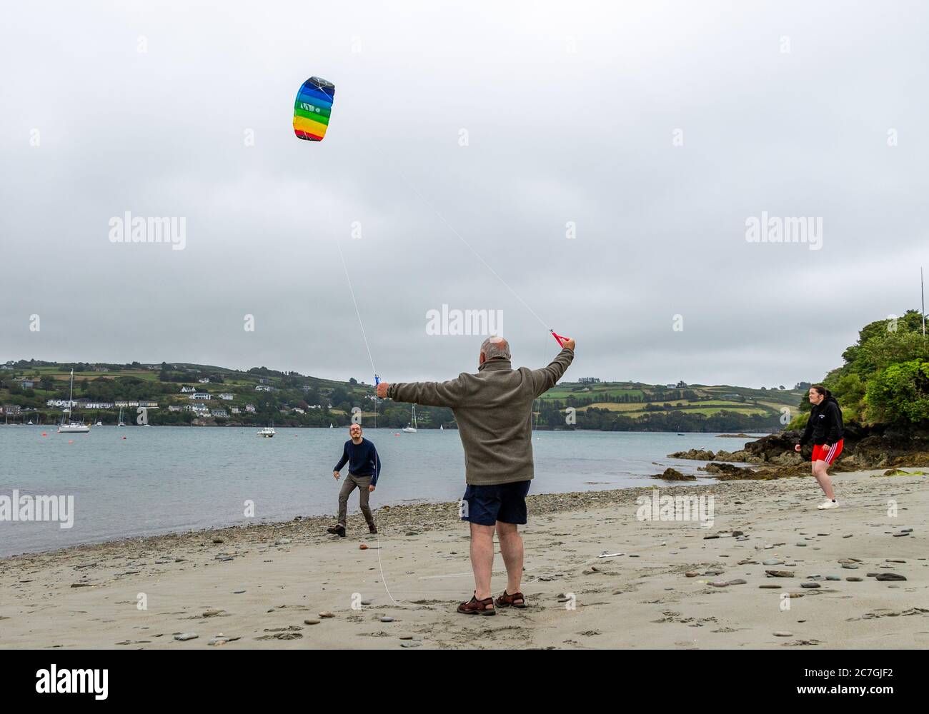 Famiglia che vola un aquilone sulla spiaggia, Union Hall, West Cork, Irlanda Foto Stock