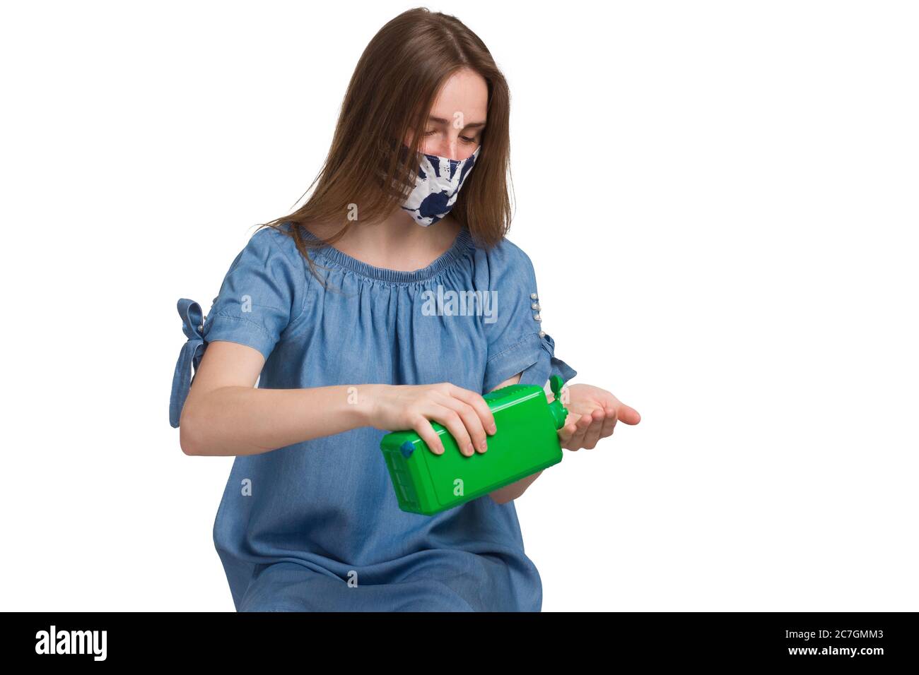 indossare una maschera medica, lavando le mani da una bottiglia verde di antisettico. Il concetto di igiene al momento del virus e della quarantena Foto Stock