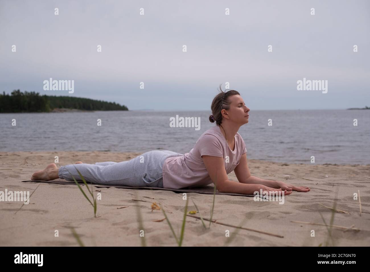 Donna che fa il Cobra Yoga stretch su tappetino yoga Foto Stock