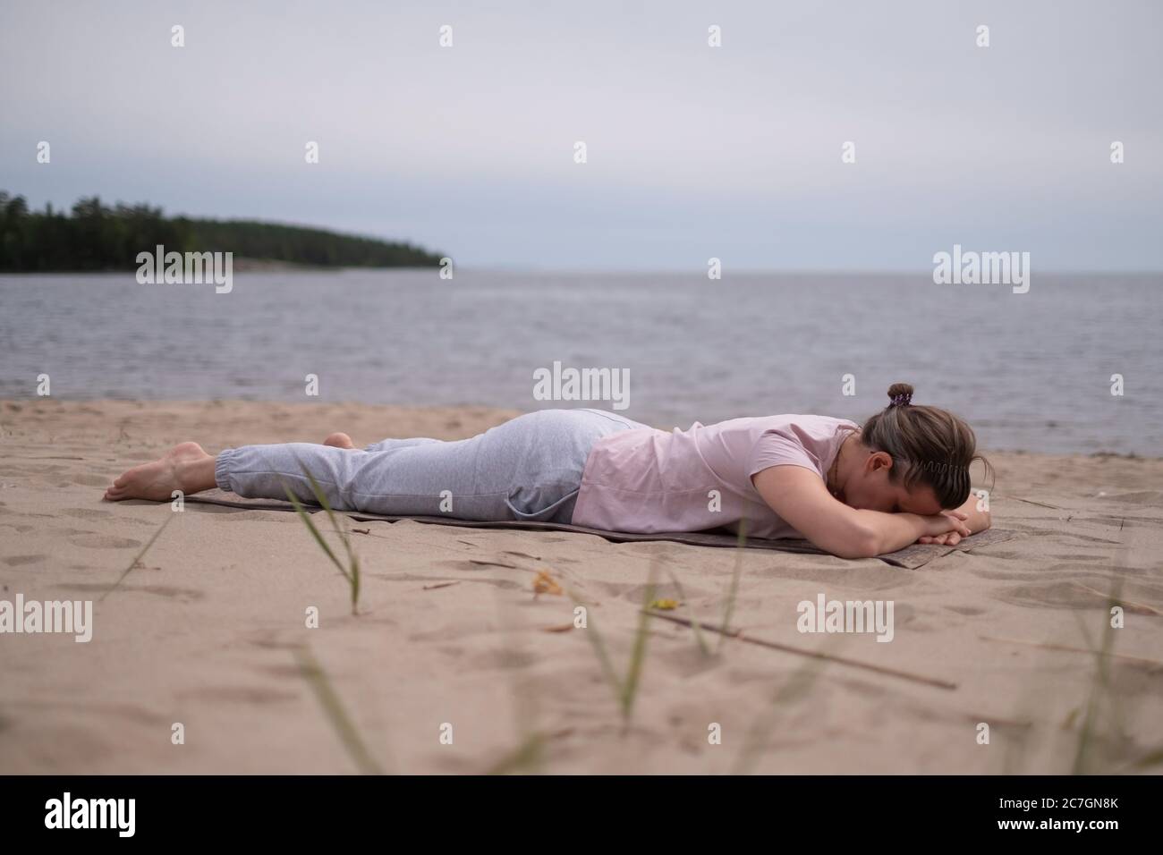 Donna sportiva rilassante in yoga asana Makarasana o coccodrillo posa Foto Stock