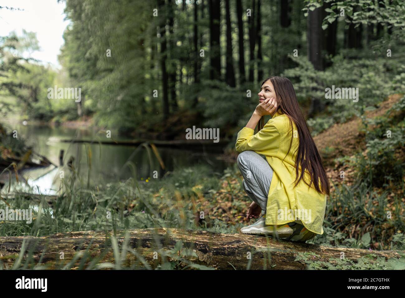 Carina bruna ragazza che si diverte durante l'escursione nella foresta in bella primavera giorno. Donna che esplora la natura Foto Stock