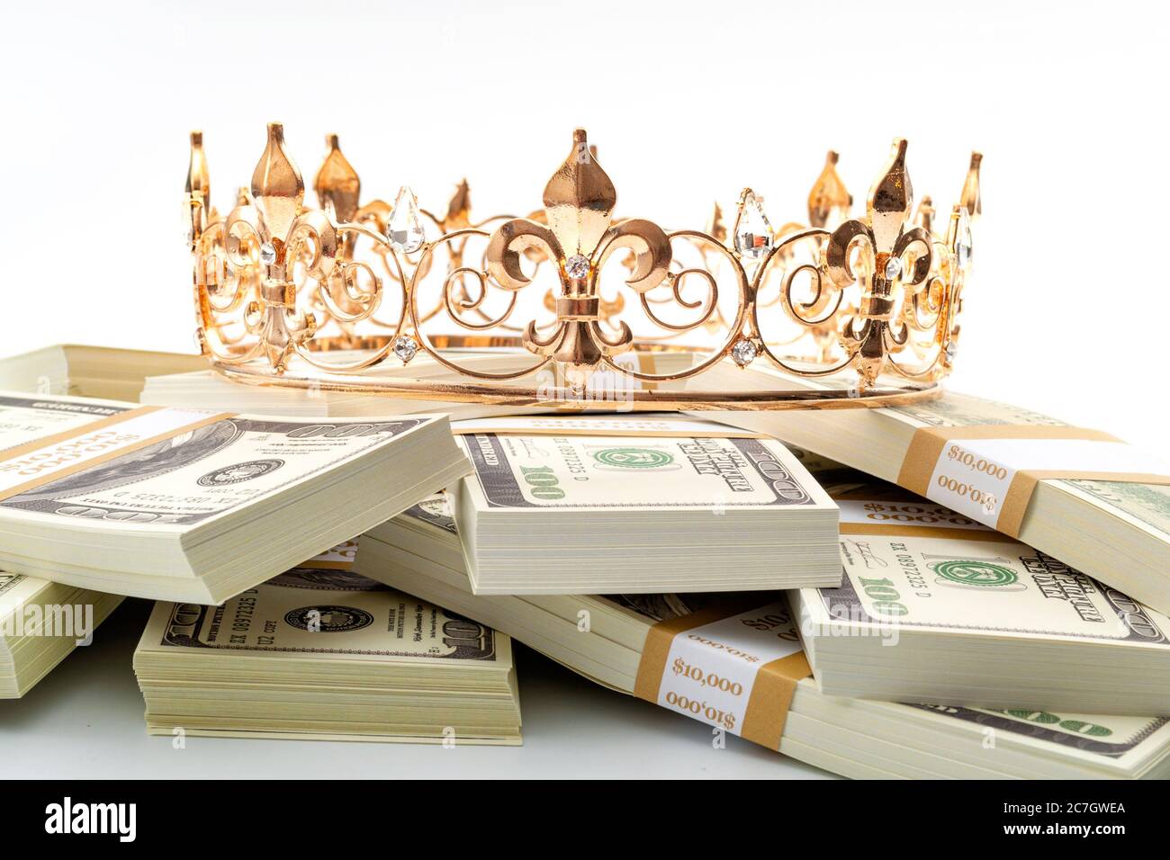 Il denaro contante è re, tesoro economico e finanziario di successo pensionamento idea concettuale con oro metallo corona su palo di 100 dollari bollette isolato su whit Foto Stock
