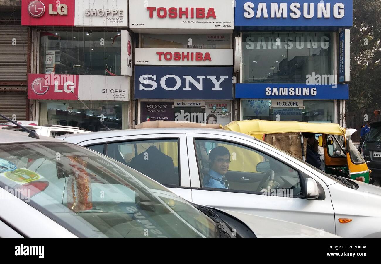 Delhi, India - LG, SONY, TOSHIBA, e SAMSUNG negozi di elettronica fianco a fianco. Traffico confettura a Delhi, capitale dell'India. Foto Stock