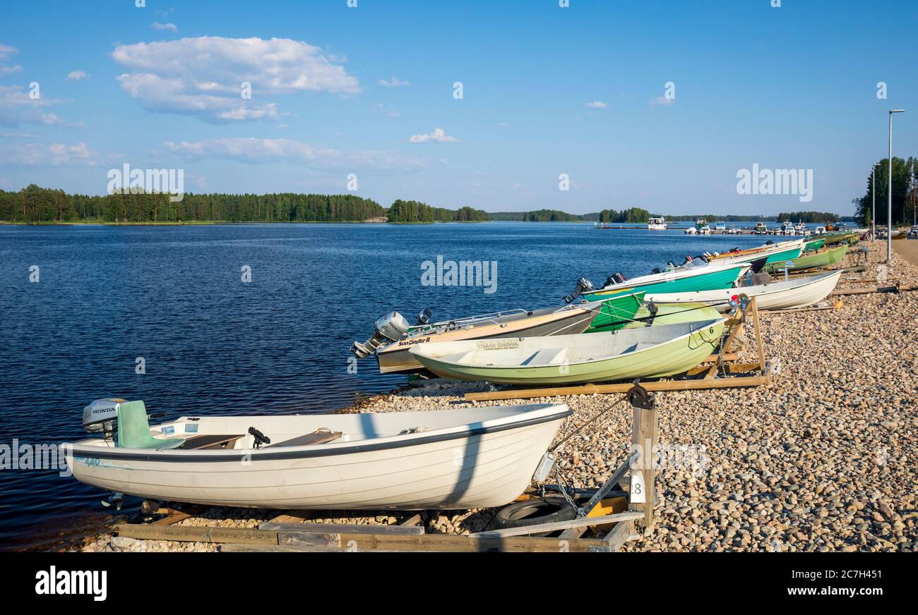 Piccole barche a motore in vetroresina / skiffs ormeggiate al Lago Kallavesi in estate , Kuopio , Finlandia Foto Stock