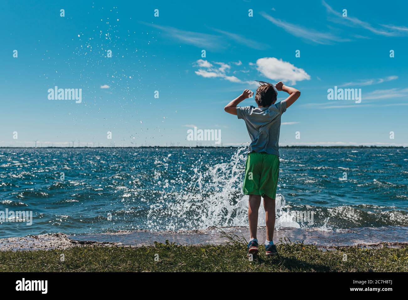 Ragazzo che si è tuffato sulla riva di un lago in una giornata estiva soleggiata. Foto Stock