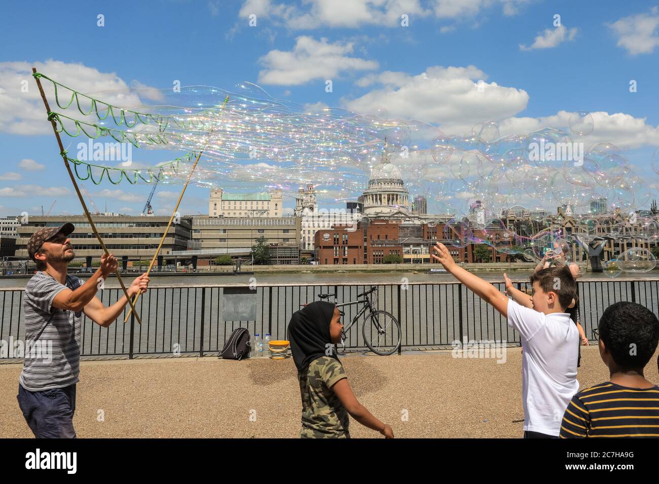 Londra, Regno Unito. 17 luglio 2020. Un'artista che fa la bolla del sapone intrattiene i bambini e gli adulti davanti ad uno splendido sfondo della Cattedrale di St Paul. Il sole e le temperature calde sono fissati per continuare nel fine settimana. Credit: Imageplotter/Alamy Live News Foto Stock