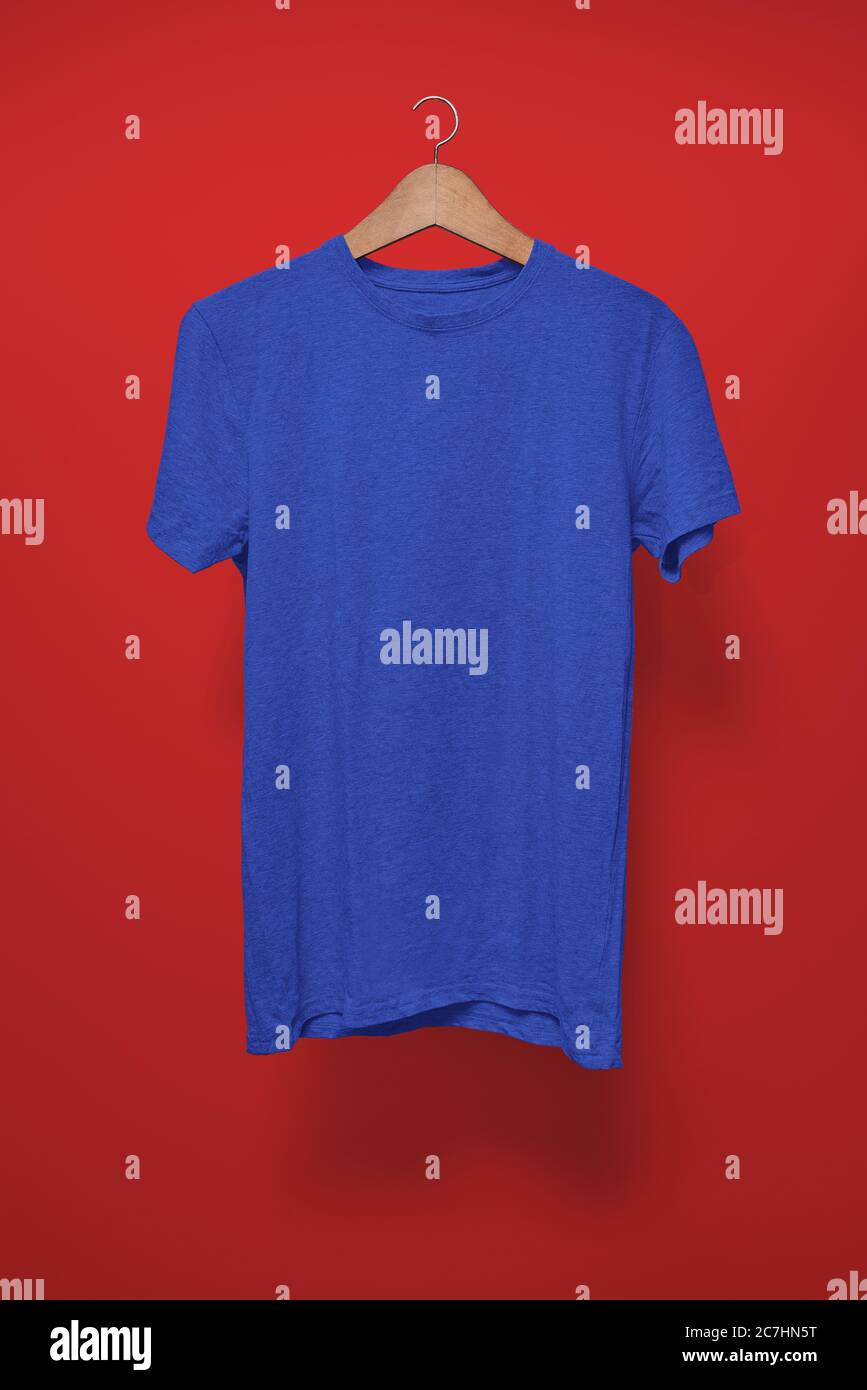 T-shirt blu scuro su un appendiabiti su sfondo rosso Foto Stock
