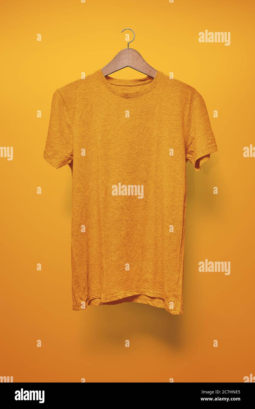 T-Shirt arancione su un appendiabiti su sfondo arancione Foto Stock