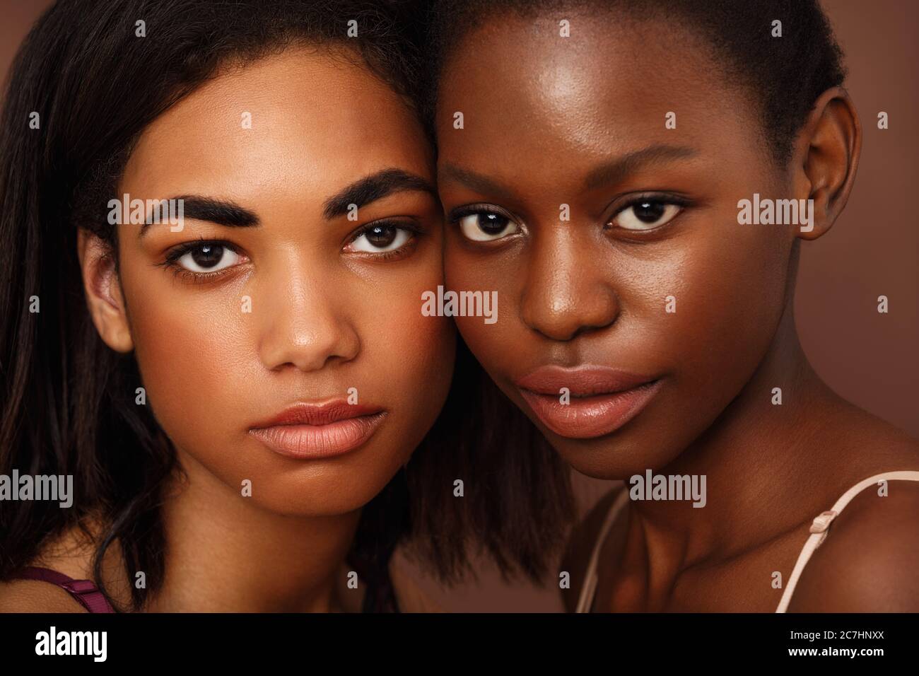 Primo piano ritratto di due belle donne afroamericane che guardano la fotocamera in studio Foto Stock