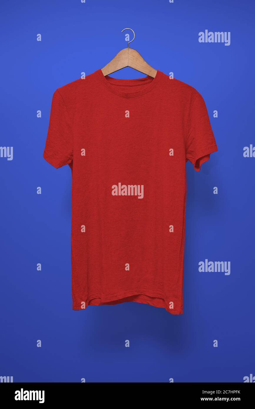 T-Shirt rossa su un appendiabiti su sfondo blu scuro Foto Stock