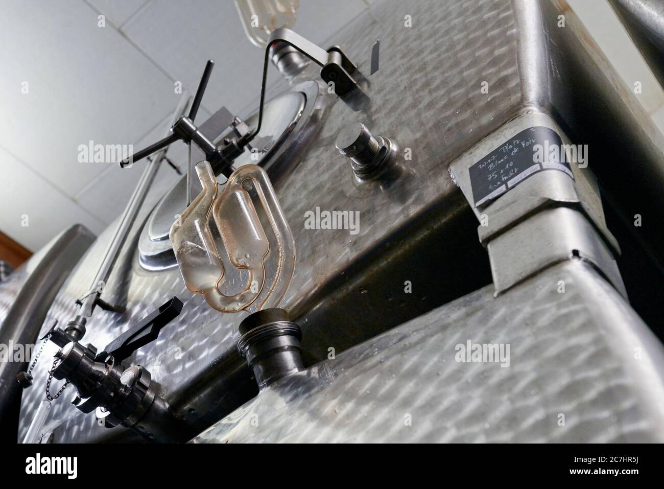 Vasche di rash in acciaio inox nella cantina di fermentazione con tubo di fermentazione, vista dal basso Foto Stock