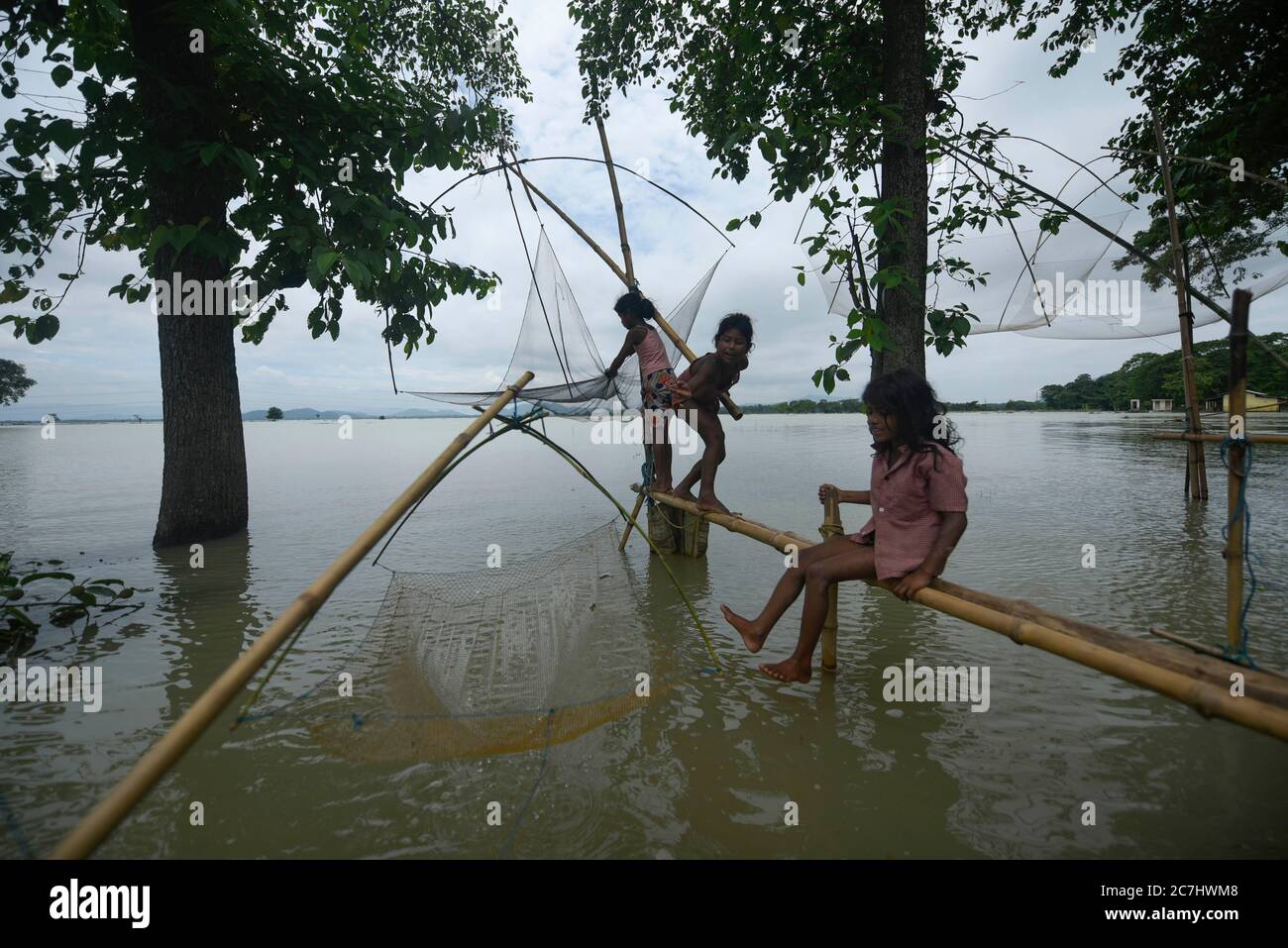 Morigaon, India. 17 luglio 2020. I bambini che pescano in un'area allagata in un villaggio alluvionale nel distretto di Morigaon di Assam in India venerdì 17 luglio 2020. Credit: David Talukdar/Alamy Live News Foto Stock