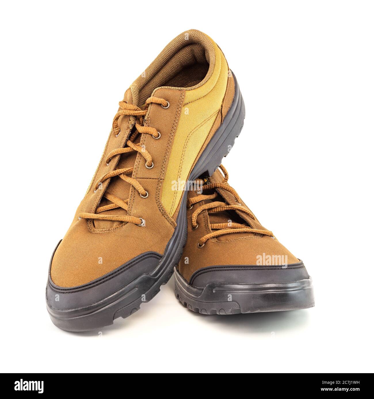 un paio di scarpe da viaggio marrone a basso costo in tessuto resistente isolato su sfondo bianco Foto Stock