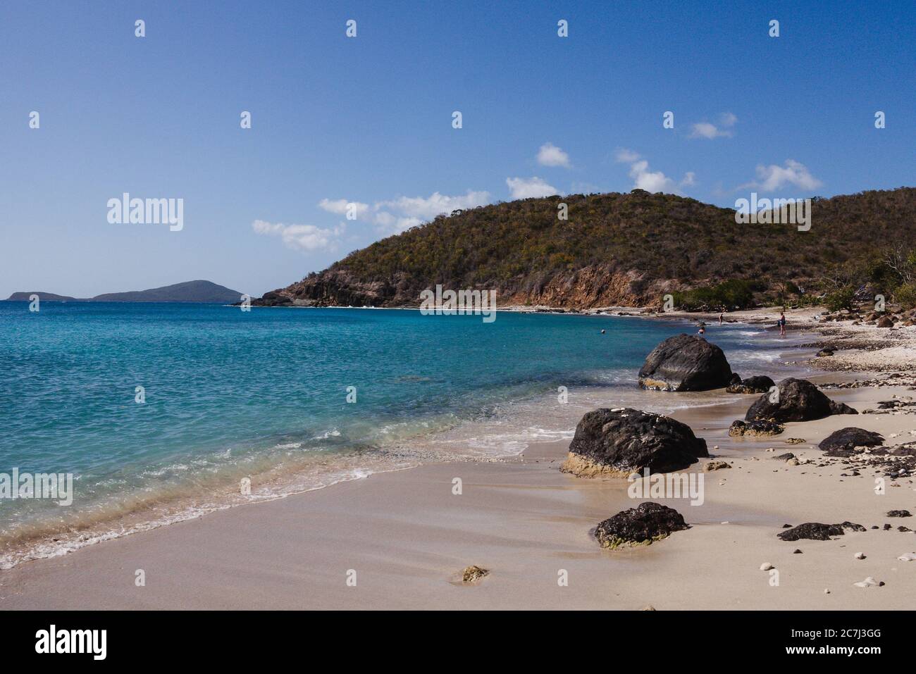 Le persone che nuotano in lontananza dalla spiaggia di Playa Punta Soldado, si affacciano sulle verdi colline e sul Mar dei Caraibi a Culebra, Puerto Rico Foto Stock