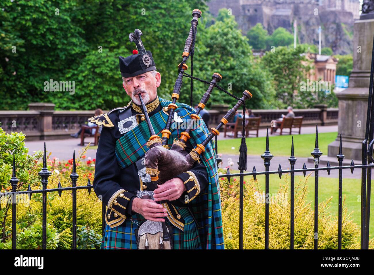 Un distinto Bagpiper serenata passanti su Princes Street a Edimburgo, Scozia Foto Stock