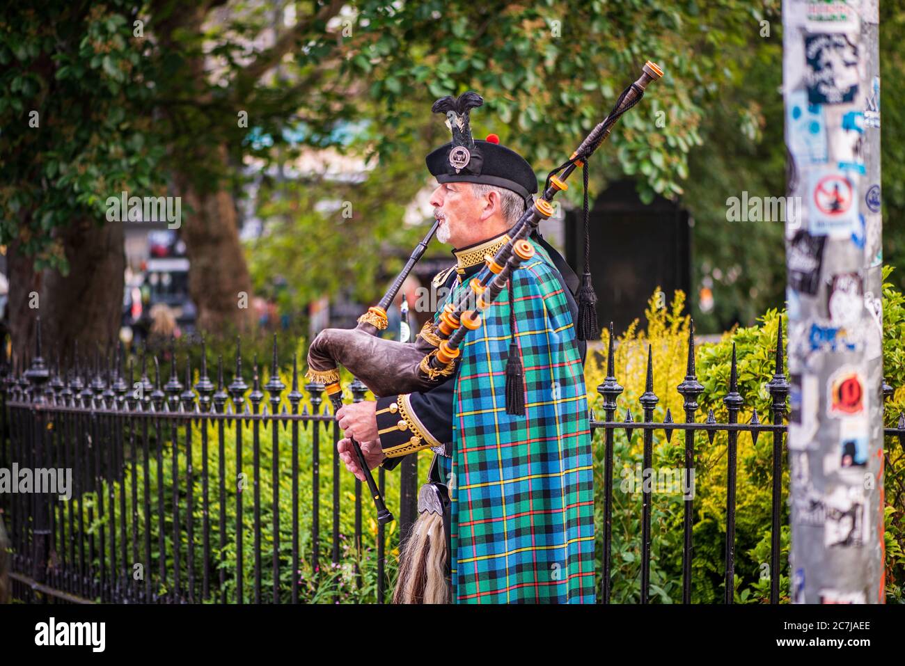 Un distinto Bagpiper serenata passanti su Princes Street a Edimburgo, Scozia Foto Stock