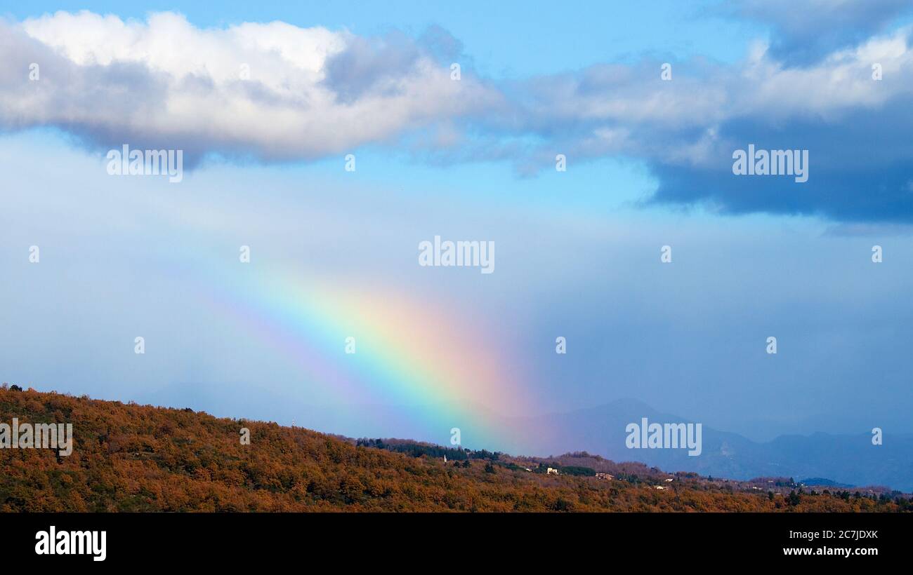 Etna, Parco Nazionale dell'Etna, Parco dell'Etna –´Etna, vista mare, arcobaleno, cielo azzurro, nuvole grigio-bianche, paesaggio autunnale degli alberi in primo piano Foto Stock