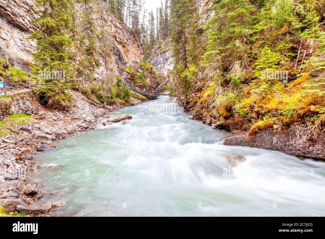 Le acque verde smeraldo dalle profonde piscine del Johnston Creek scorrono lungo il sentiero escursionistico del Johnson Canyon nel Banff National Park, dove le mura Foto Stock