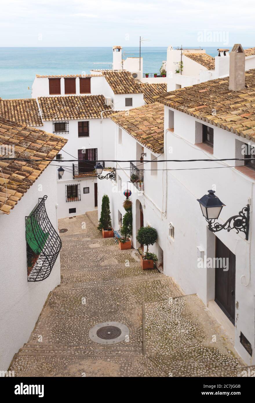 Gradini in una strada stretta con case bianche e vista sull'oceano nella città vecchia di Altea, Costa Blanca, Spagna Foto Stock