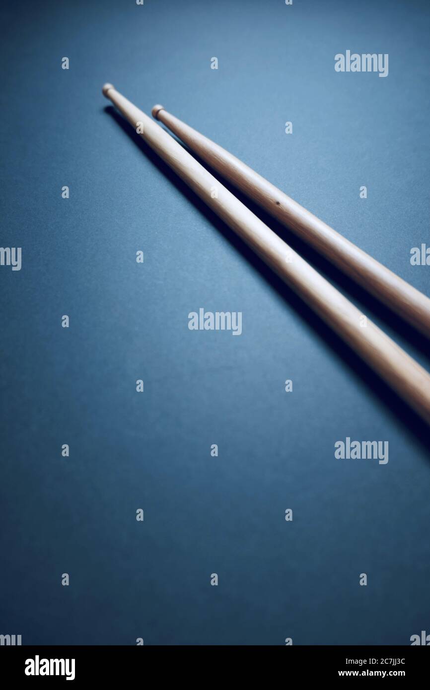 Immagine verticale ad angolo alto di due drumsticks su un blu superficie Foto Stock