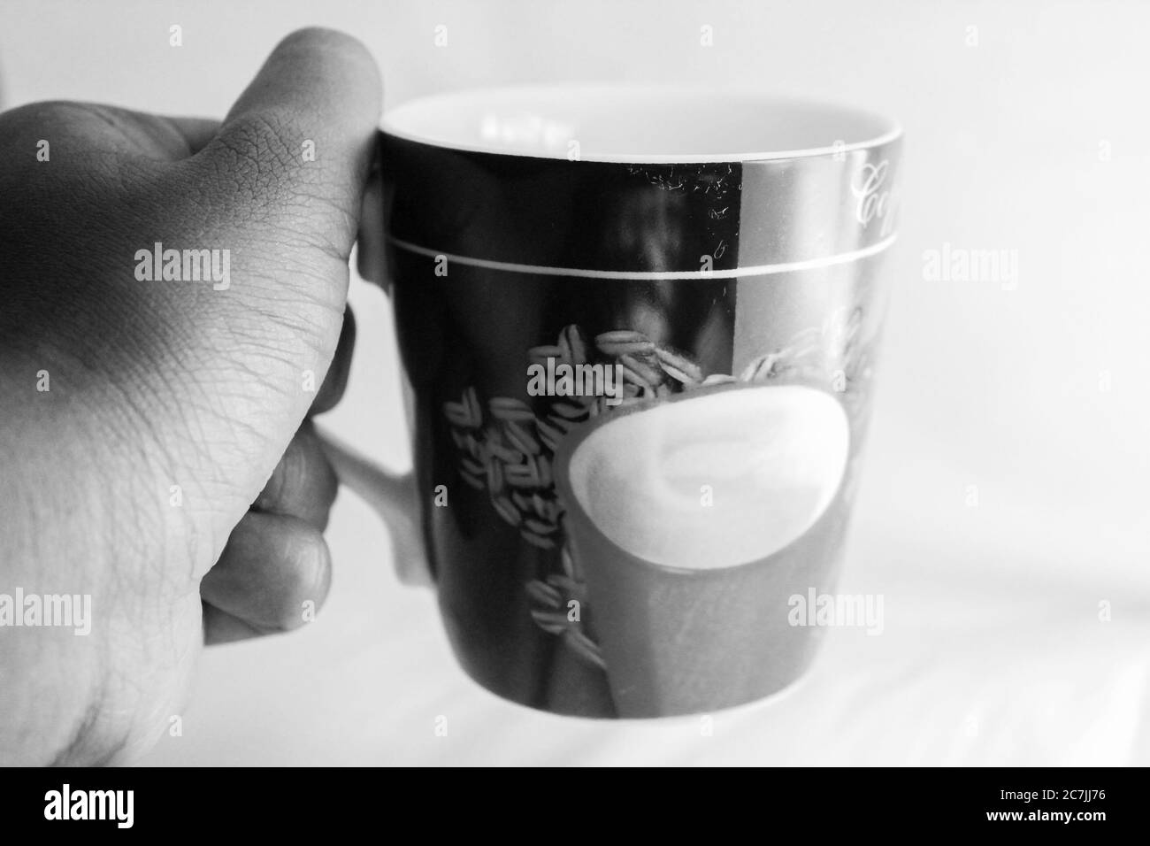 Una tazza di caffè su una mano Foto Stock