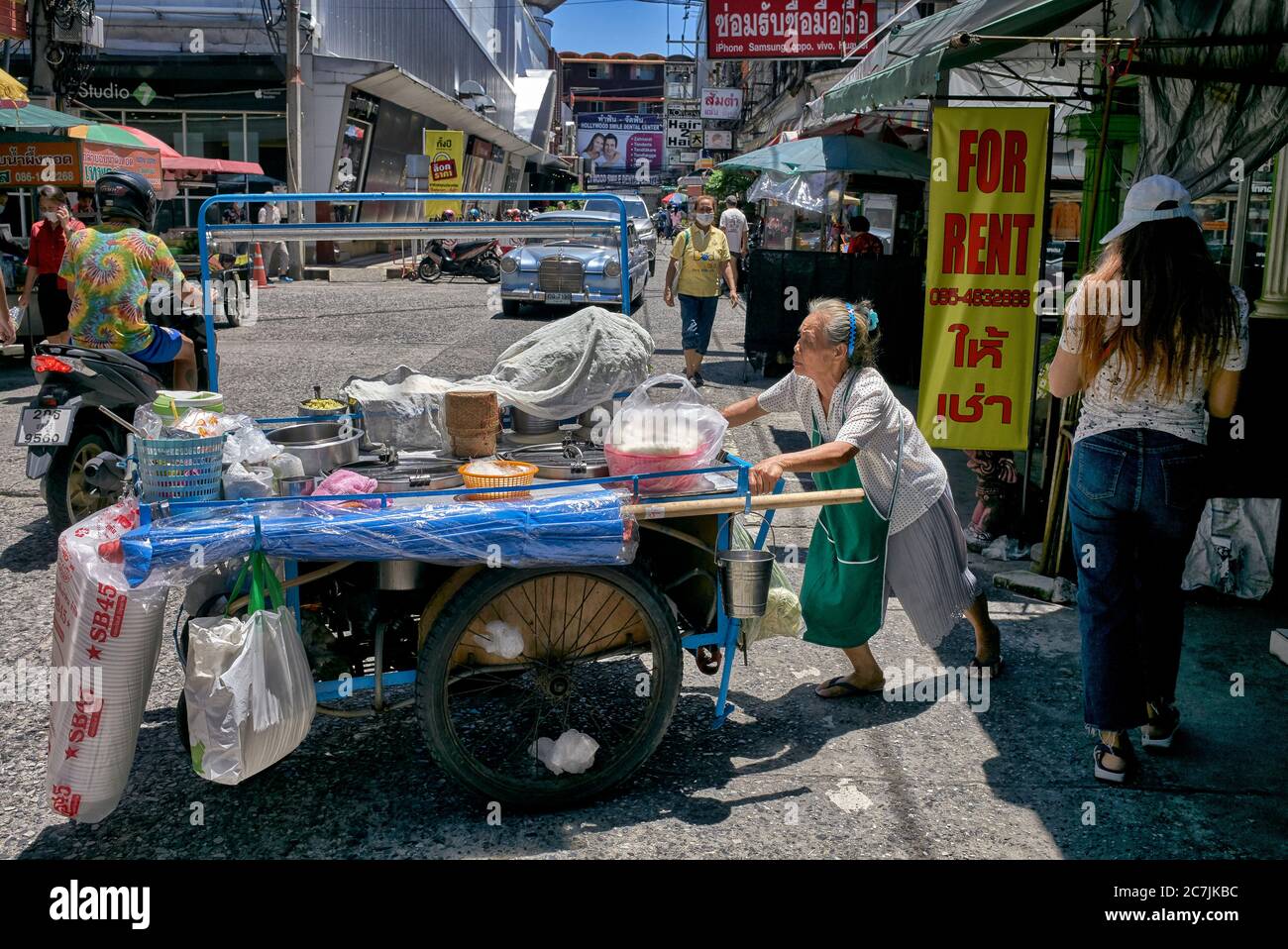 Donna anziana che lavora. Vendita di cibo di strada che spinge carrello a mano. Thailandia Sud-est asiatico Foto Stock
