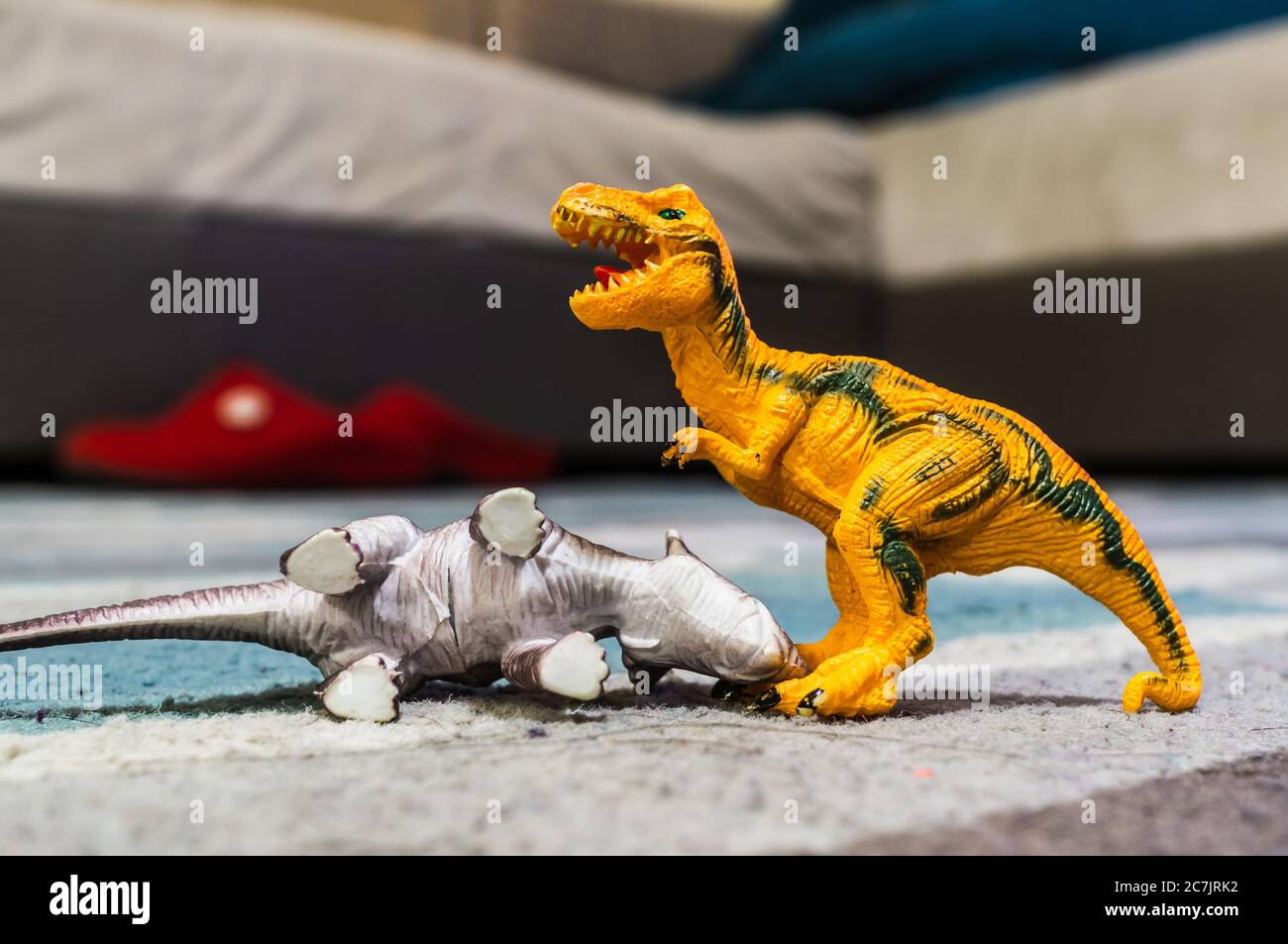 Primo piano di due dinosauri giocattolo posti a terra in camera da letto Foto Stock