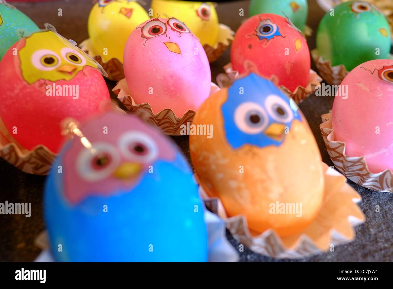 Uova di Pasqua colorate con adesivi che sembrano polli appena sfornati Foto Stock