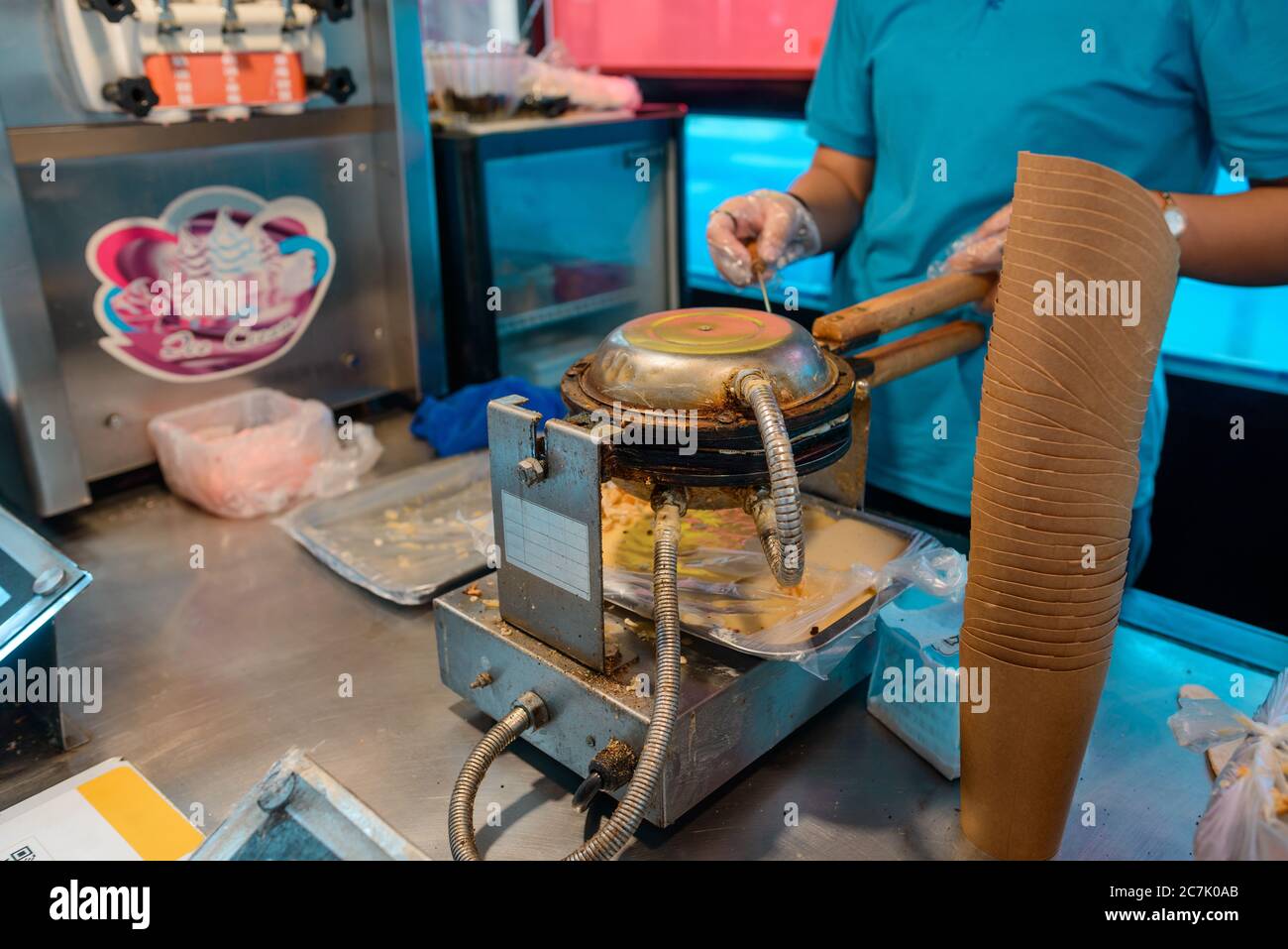 Venditore di strada che prepara un waffle all'uovo per le sundae Foto Stock