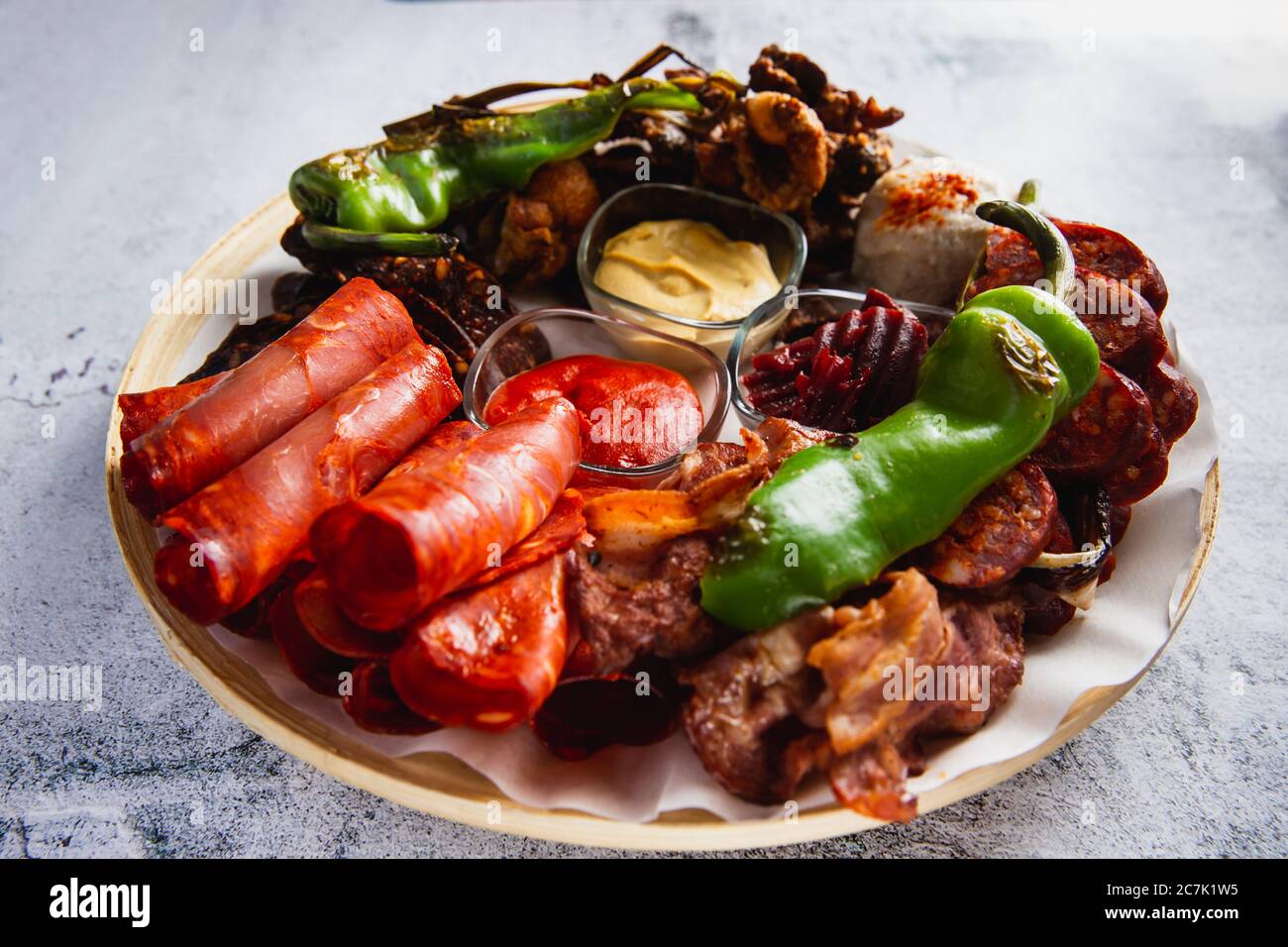 Carne assortita e salsicce e verdure alla griglia su un piatto rotondo Foto Stock