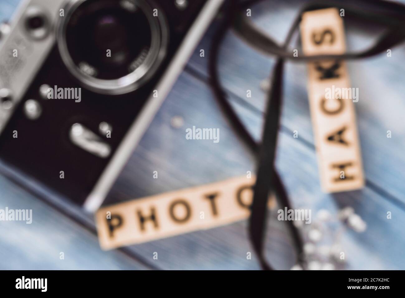 Sfondo a fuoco morbido, sfocatura ripresa della fotocamera vintage sul piano di lavoro grigio ardesia chiaro con un'iscrizione di foto hacks Foto Stock