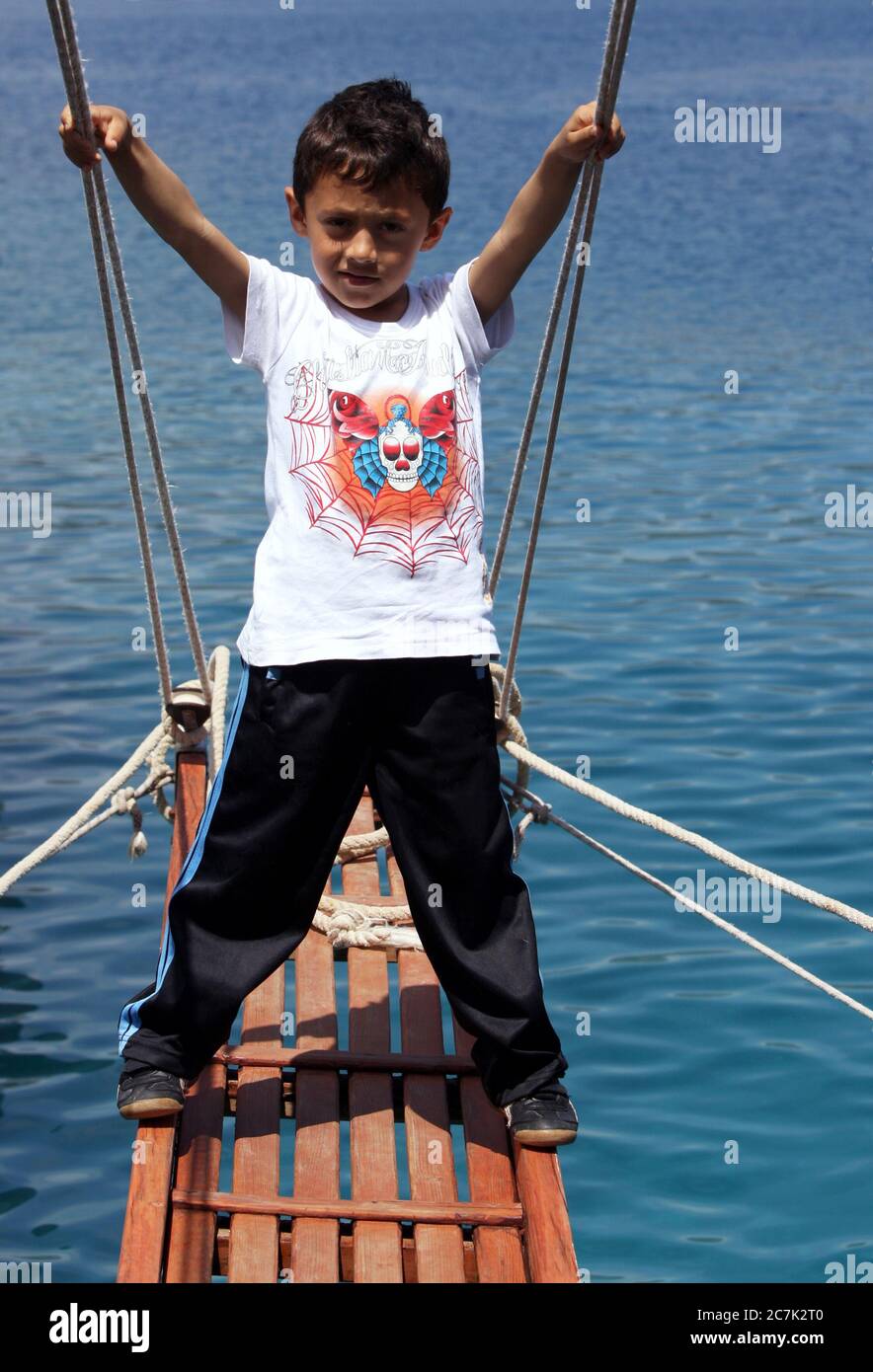 Un ragazzo turco si trova sulla sponda di una nave da crociera in un tour della regione di Kekova e del Mar Mediterraneo sulla costa meridionale dei Turchi. Foto Stock