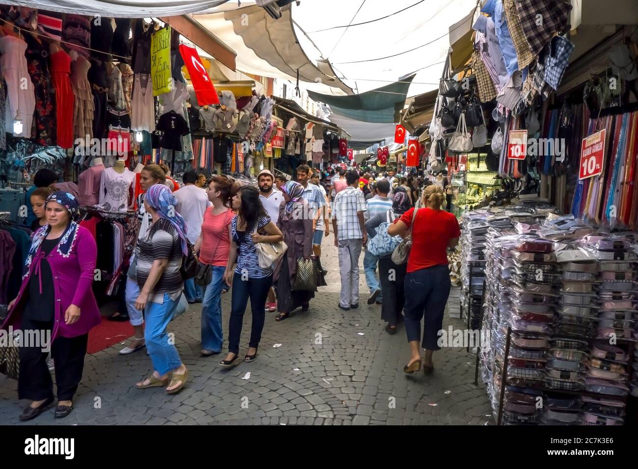 La gente passeggia davanti ai negozi di abbigliamento all'interno del bazar di Izmir in Turchia. Foto Stock