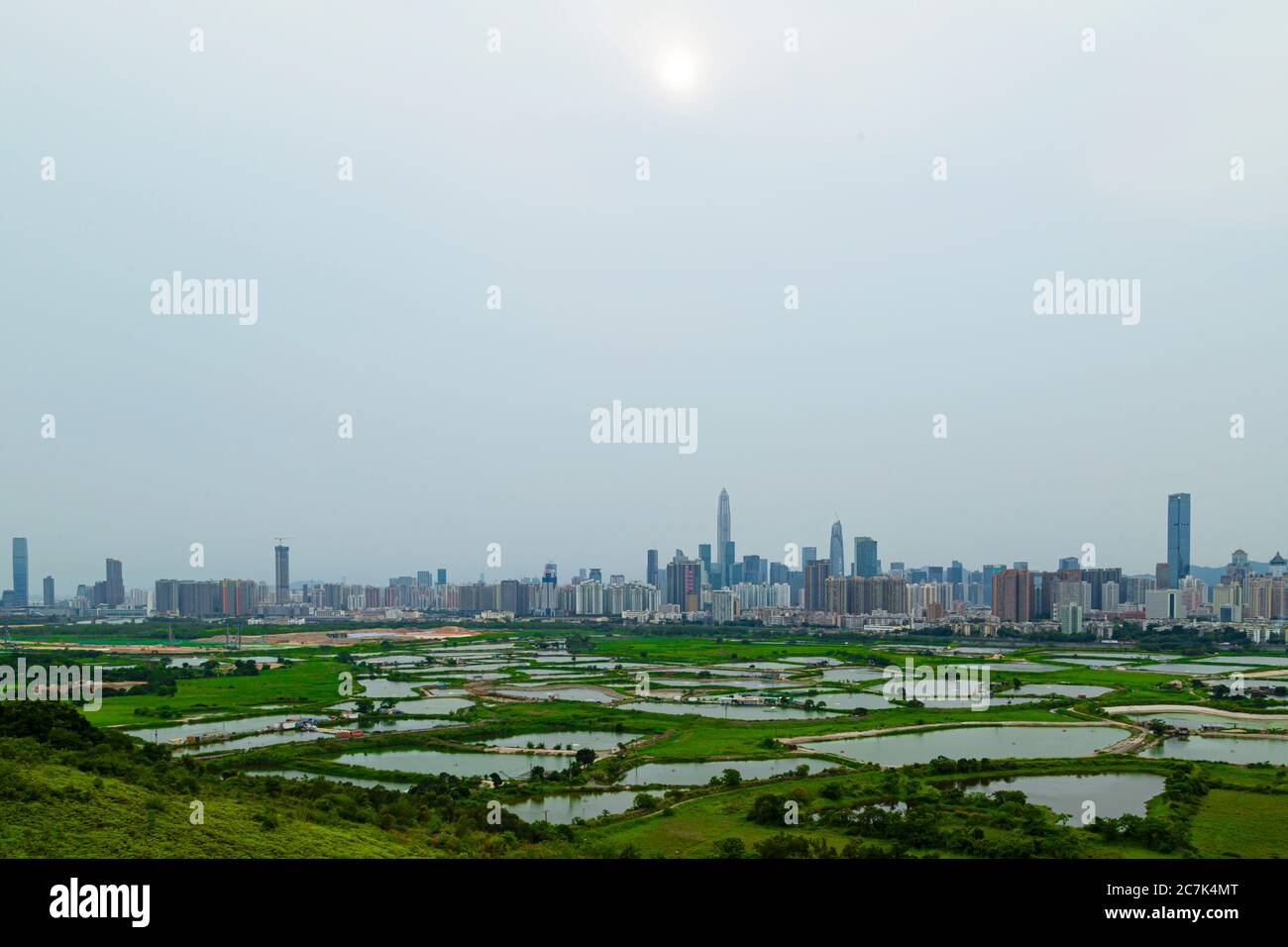 La vista di Shenzhen da ma Tso Lung, Hong Kong. Guarda i grattacieli di Shenzhen dietro il laghetto di pesci situato a Hong Kong, che si separa dal fiume Shenzhen. Foto Stock