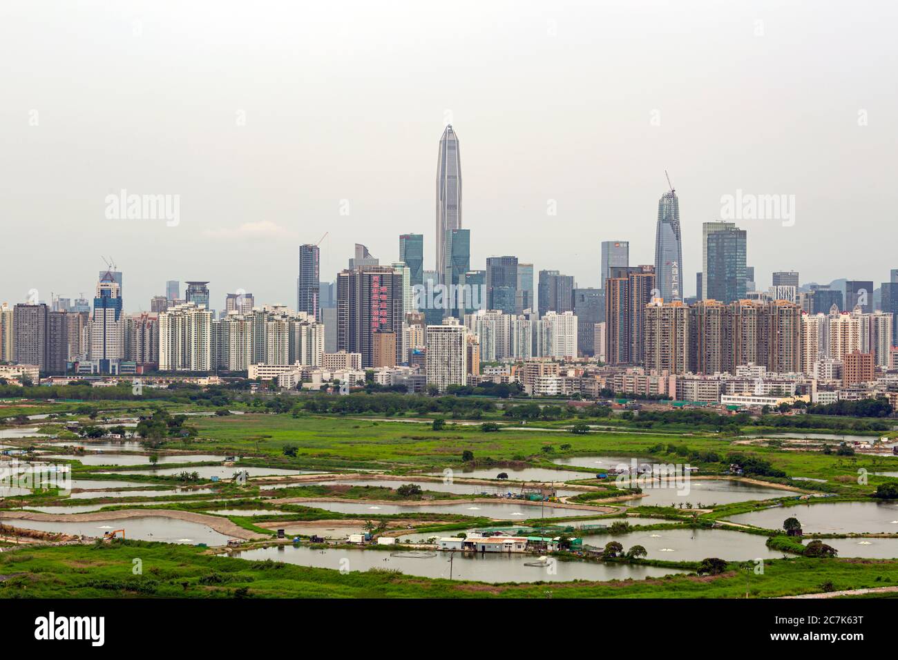 La vista di Shenzhen da ma Tso Lung, Hong Kong. Guarda i grattacieli di Shenzhen dietro il laghetto di pesci situato a Hong Kong, che si separa dal fiume Shenzhen. Foto Stock