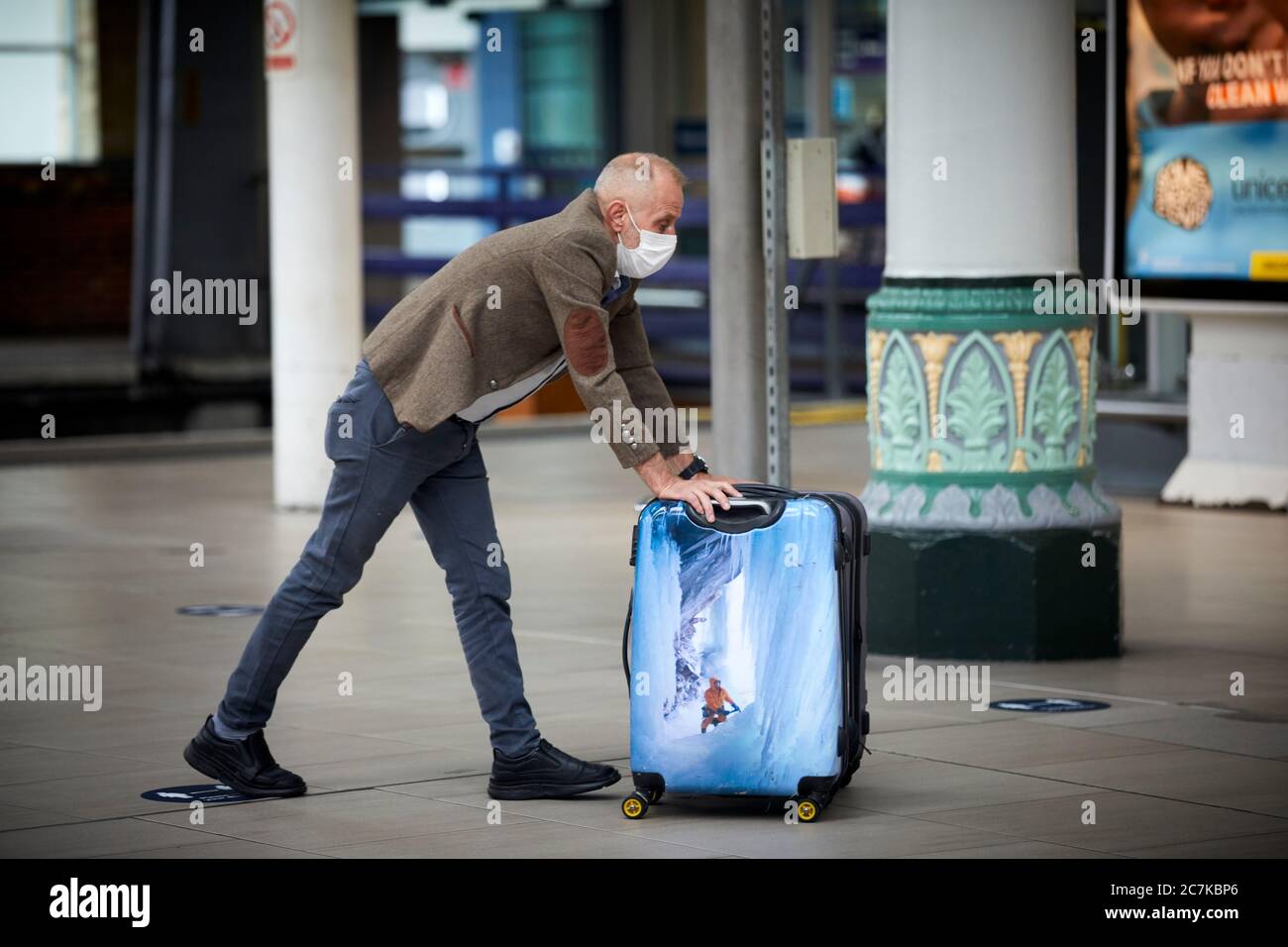 Manchester Piccadilly passeggero della stazione ferroviaria indossando la sua maschera Foto Stock