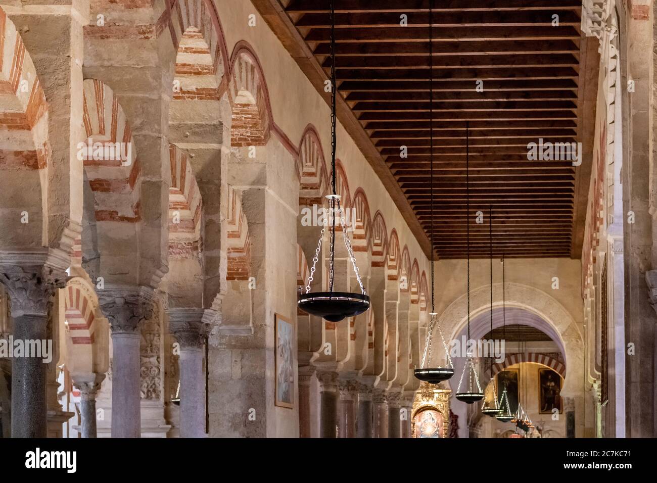 Una fila di lampade si affaccia sulle arche di Abd-ar-Rahman II nella moschea-cattedrale di Cordoba Foto Stock